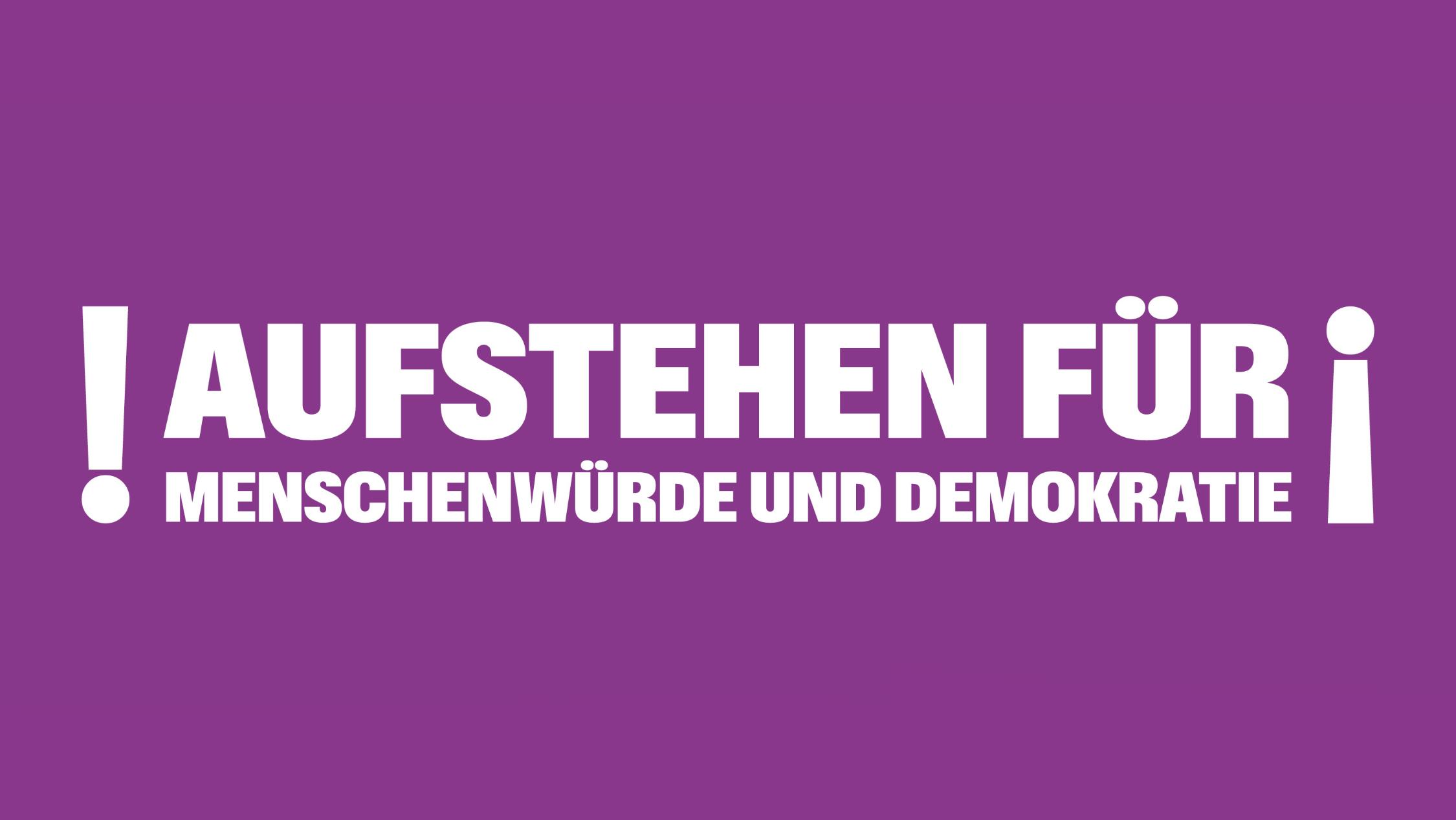 Auf lila Hintergrund steht Aufstehen für Menschenwürde und Demokratie; umrahmt von Ausrufezeichen