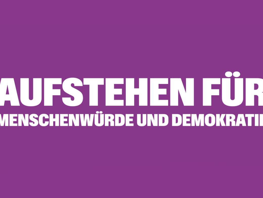 Auf lila Hintergrund steht Aufstehen für Menschenwürde und Demokratie; umrahmt von Ausrufezeichen