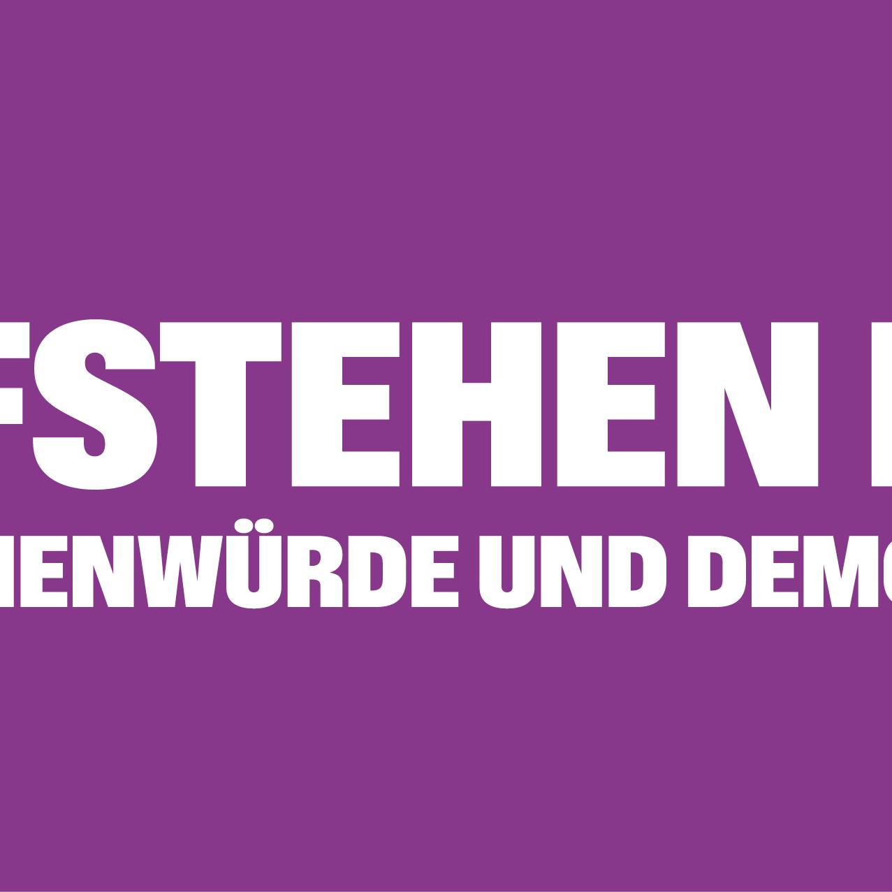 Auf einem lila Banner steht 'Aufstehen für Menschnwürde und Demokratie', rechts und links mit Ausrufezeichen umrahmt