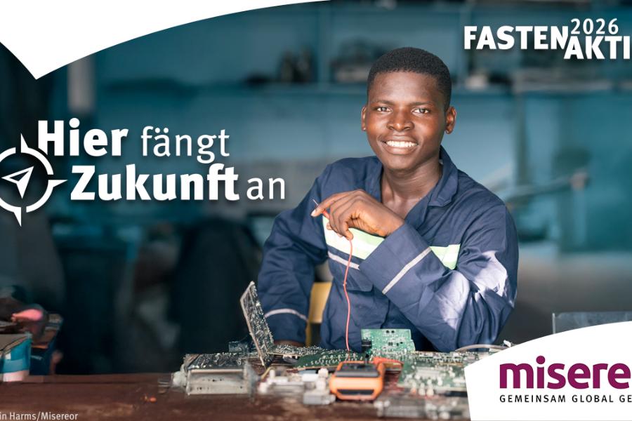 Dunkelhäutiger junger Mann in Dienstkleidung sitzt in einer Werkstatt am Tisch und arbeitet an Elektronik; Schriftzug: 'Hier fängt die Zukunft an'