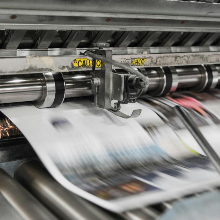 (c) unsplash.com Zeitung läuft in hoher Geschwindigkeit durch eine Druckanlage.