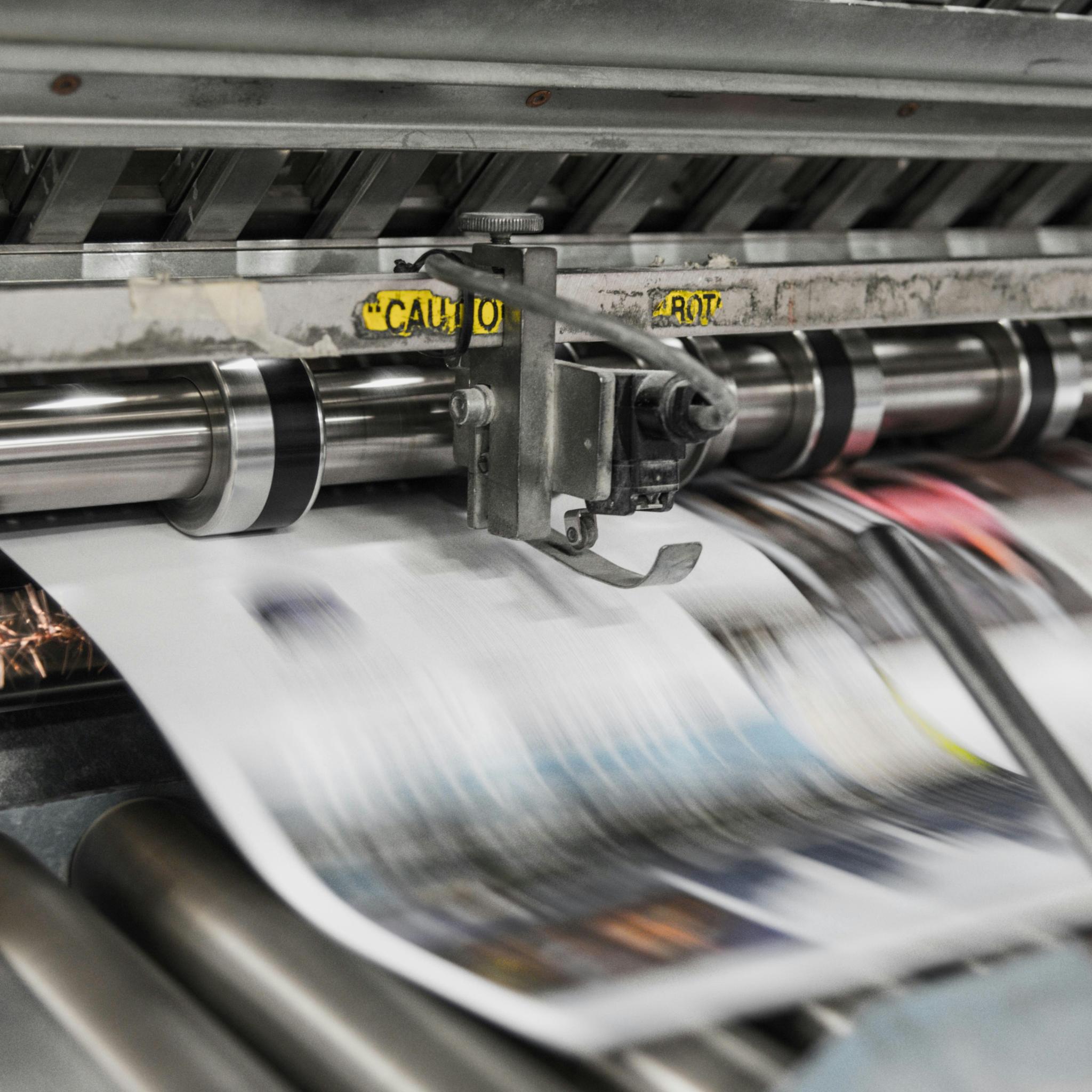 Zeitung läuft in hoher Geschwindigkeit durch eine Druckanlage.