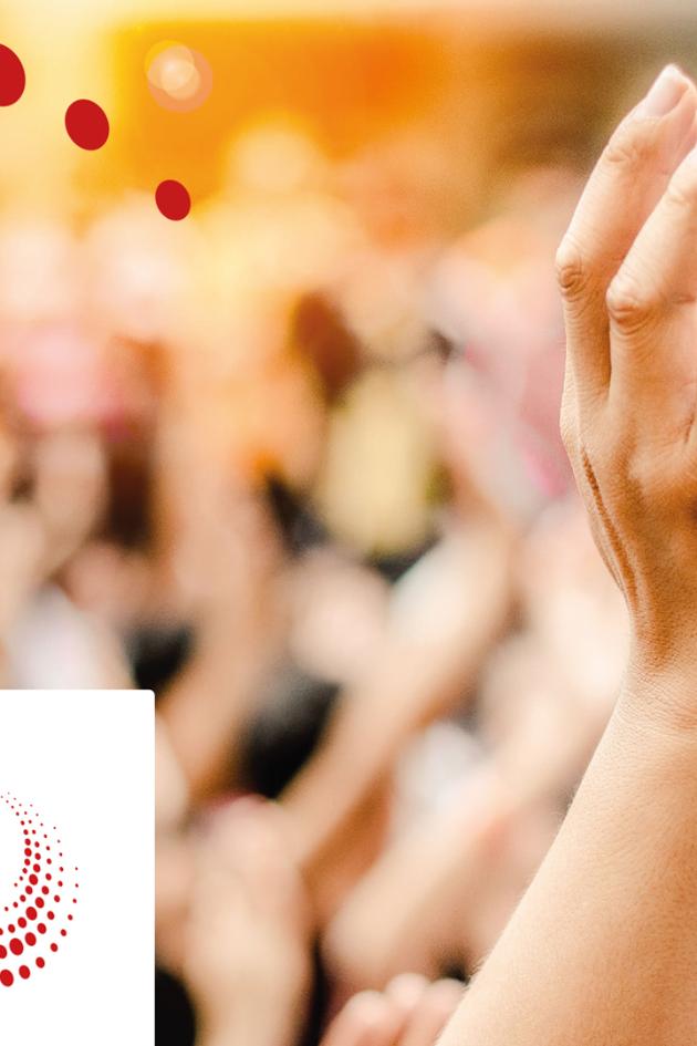 Eine Hand streckt sich in die Höhe, im Hintergrund sind verschwommen noch zahlreiche Menschen und hochgehobene Hände zu sehen.