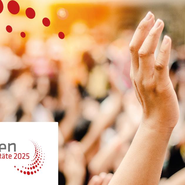 Eine Hand streckt sich in die Höhe, im Hintergrund sind verschwommen noch zahlreiche Menschen und hochgehobene Hände zu sehen.