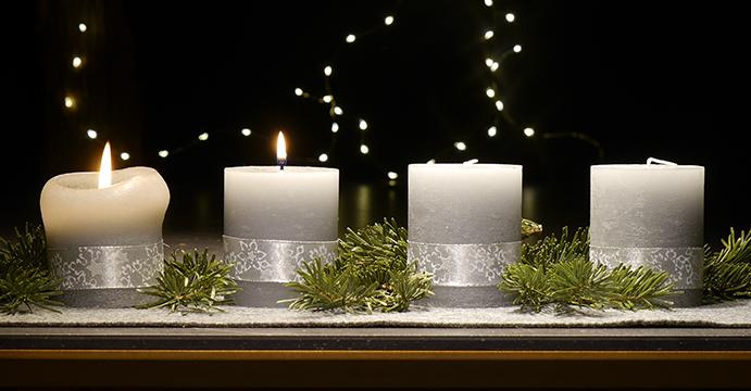An einem Adventsgesteck brennen zwei Kerzen