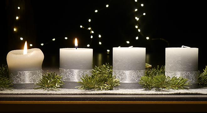 An einem Adventsgesteck brennen zwei Kerzen