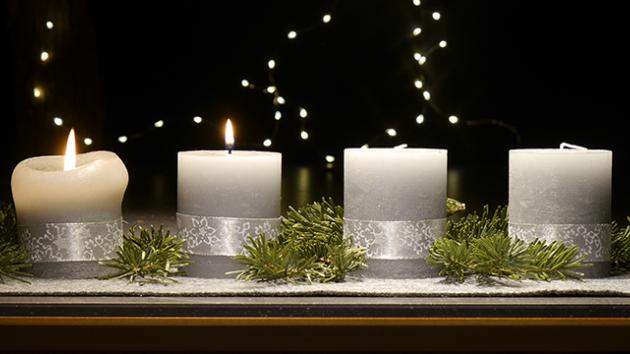 An einem Adventsgesteck brennen zwei Kerzen