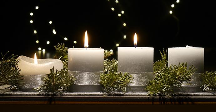 An einem Adventsgesteck brennen drei Kerzen