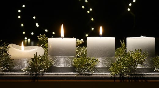 An einem Adventsgesteck brennen drei Kerzen