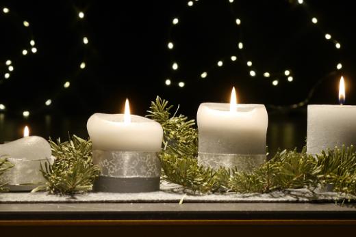 An einem Adventsgesteck brennen vier Kerzen