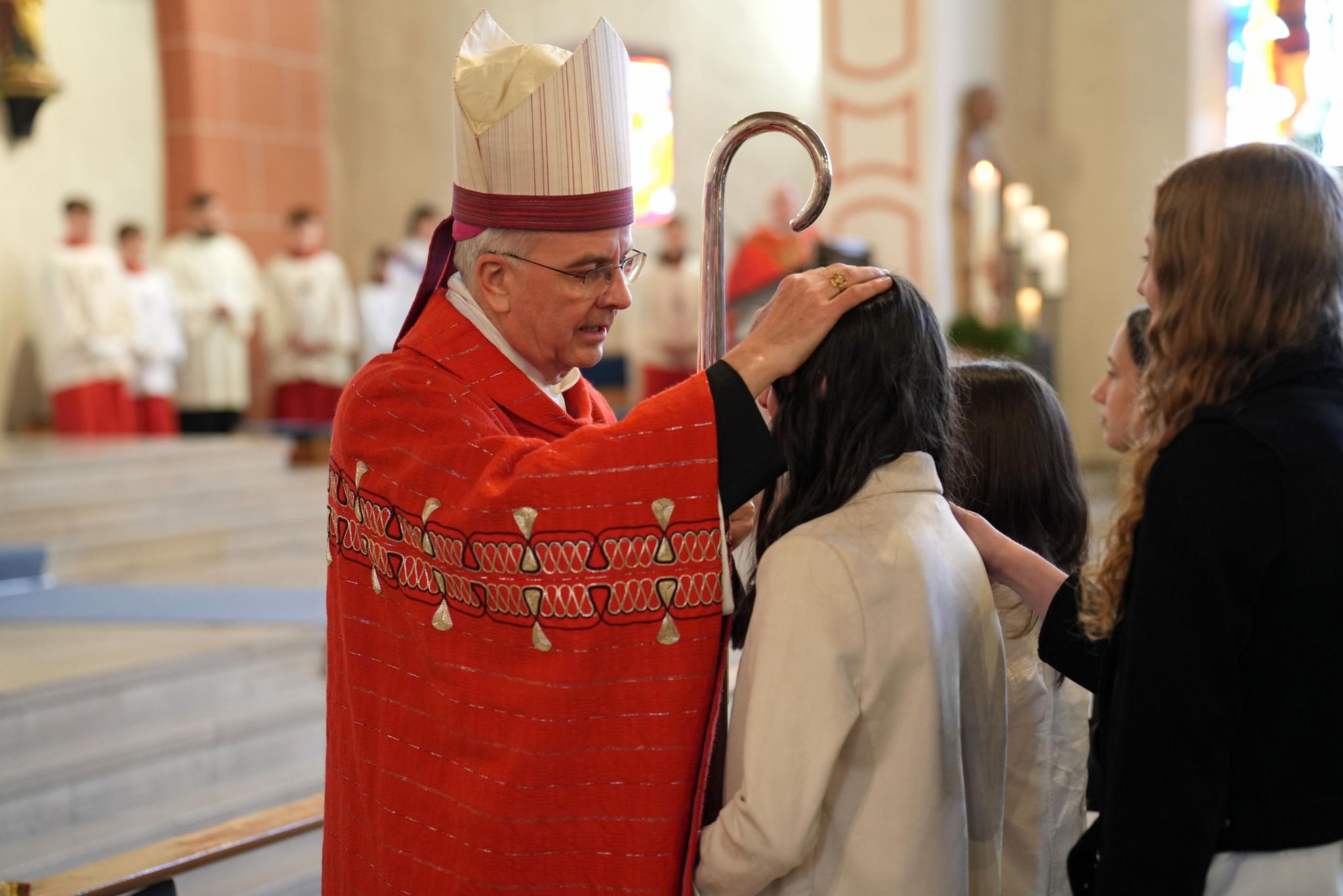 Weihbischof Peters legt einem jungen Menschen die Hand auf den Kopf.