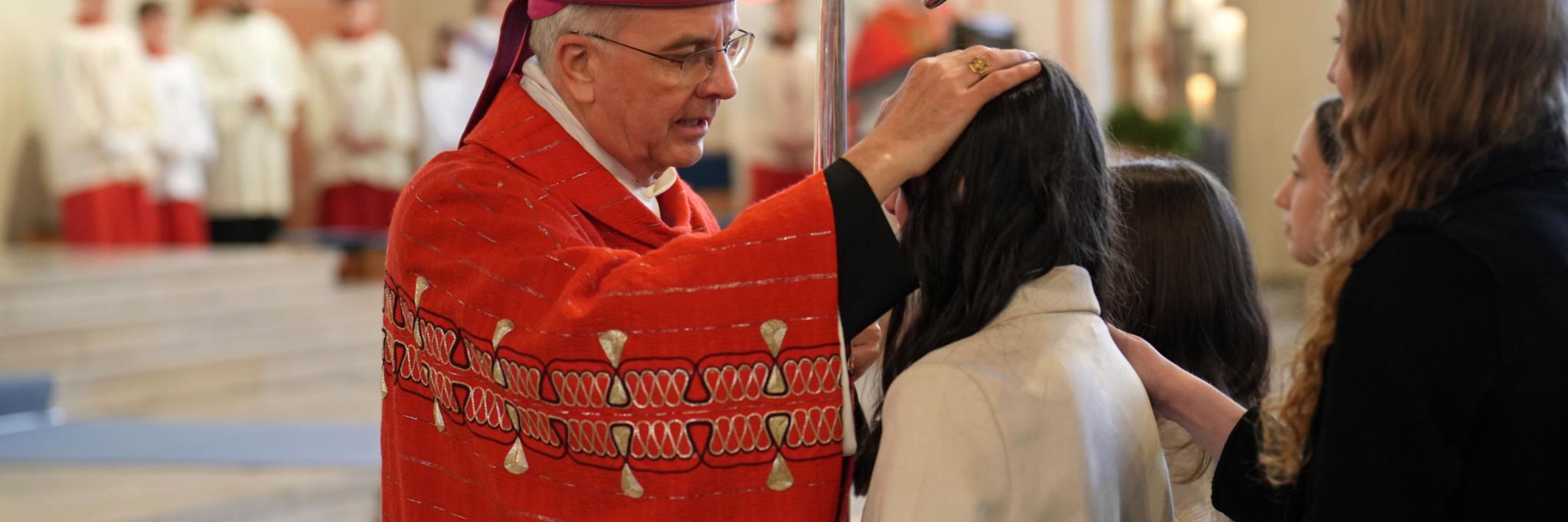 Weihbischof Peters legt einem jungen Menschen die Hand auf den Kopf.