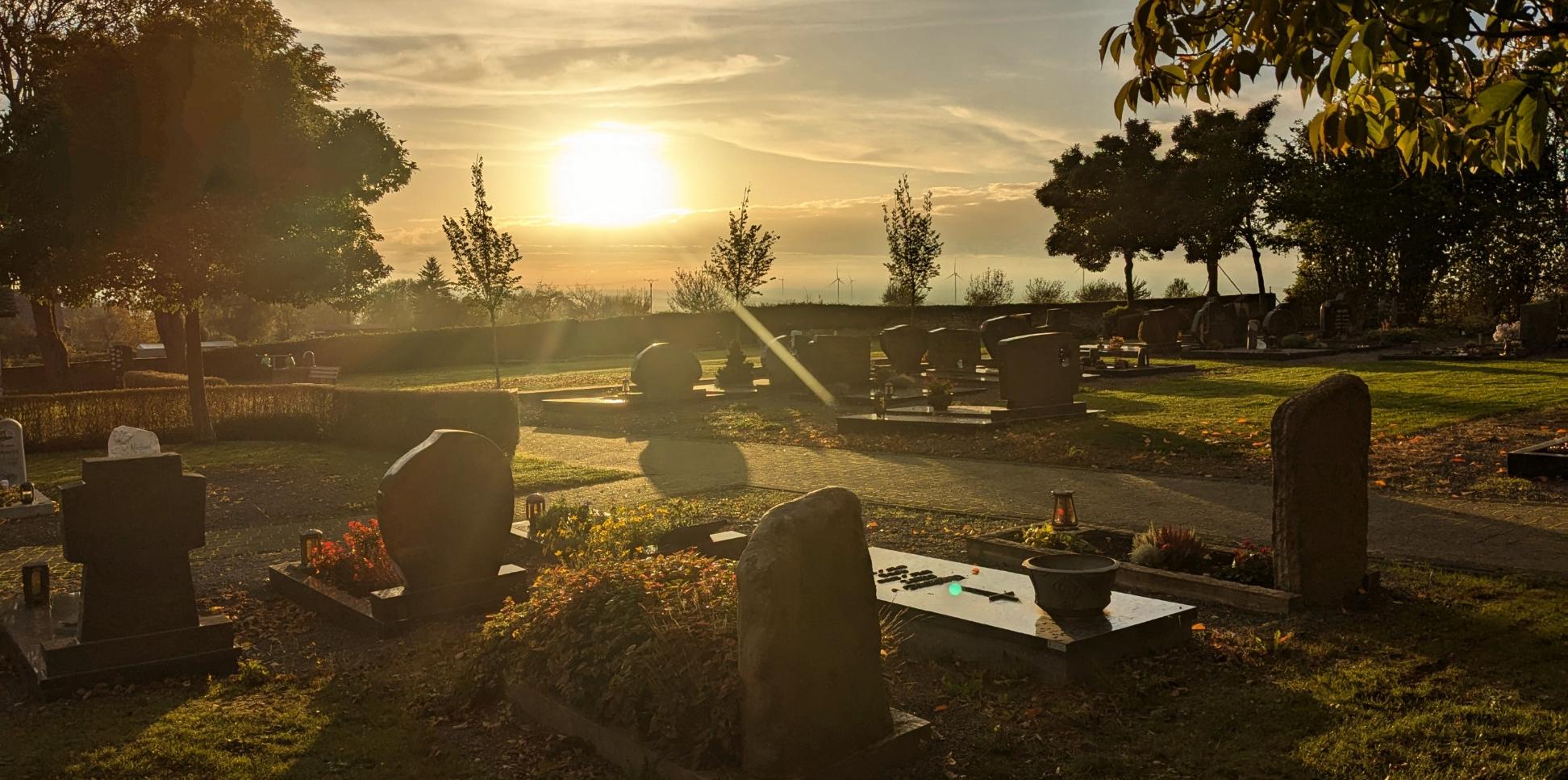 Friedhof bei untergehender Sonne und herbstlicher Stimmung