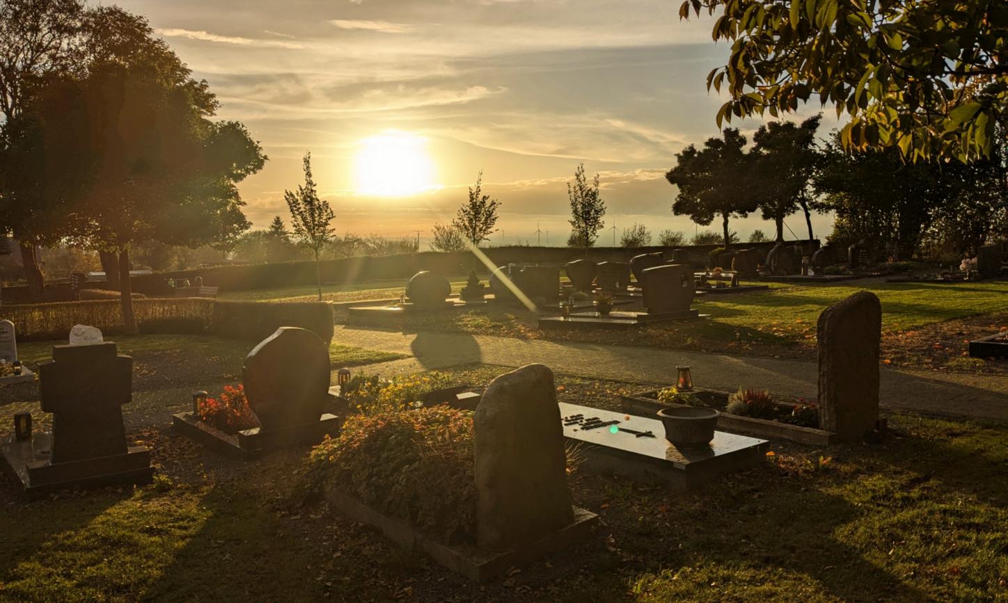 Friedhof bei untergehender Sonne und herbstlicher Stimmung