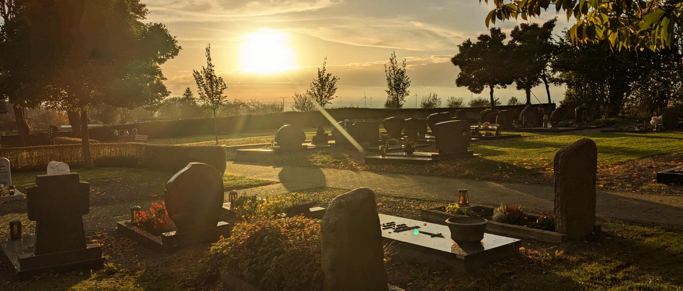 Friedhof bei untergehender Sonne und herbstlicher Stimmung