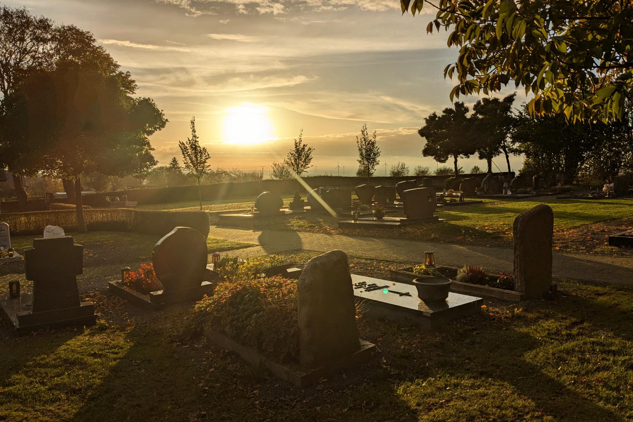 Friedhof bei untergehender Sonne und herbstlicher Stimmung
