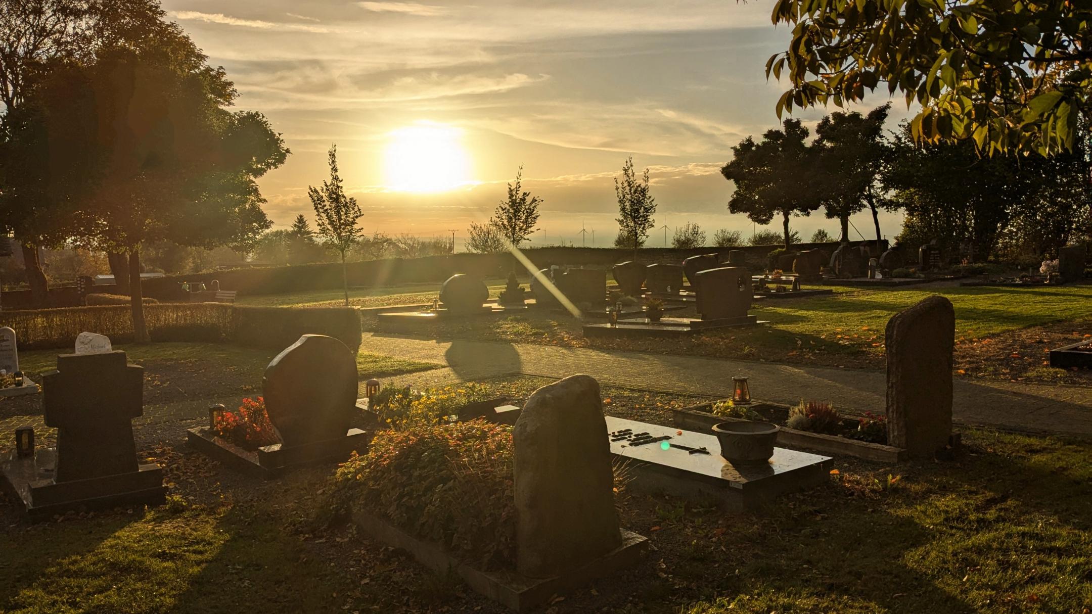 Friedhof bei untergehender Sonne und herbstlicher Stimmung