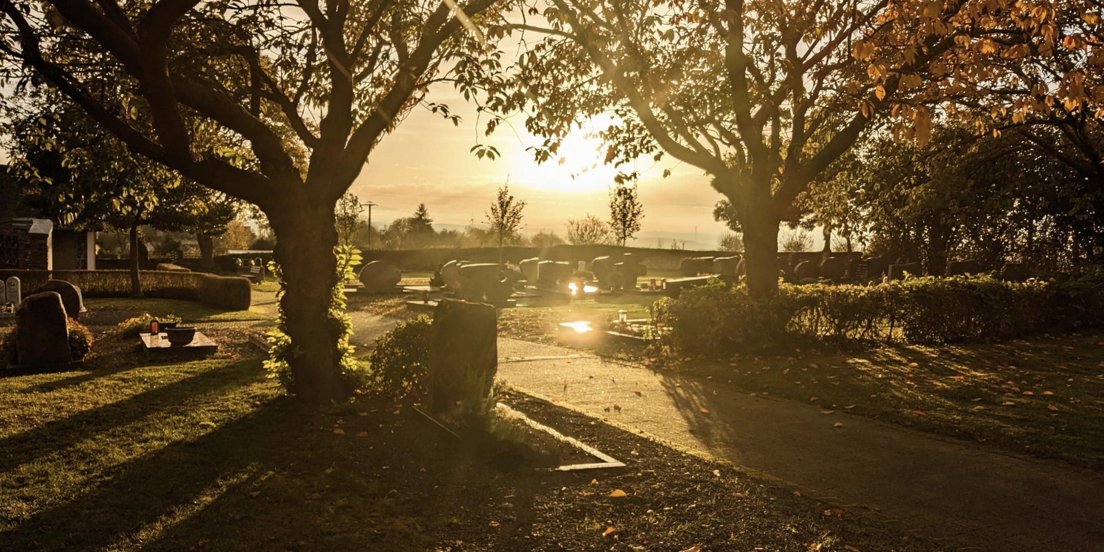 Friedhof bei untergehender Sonne und herbstlicher Stimmung