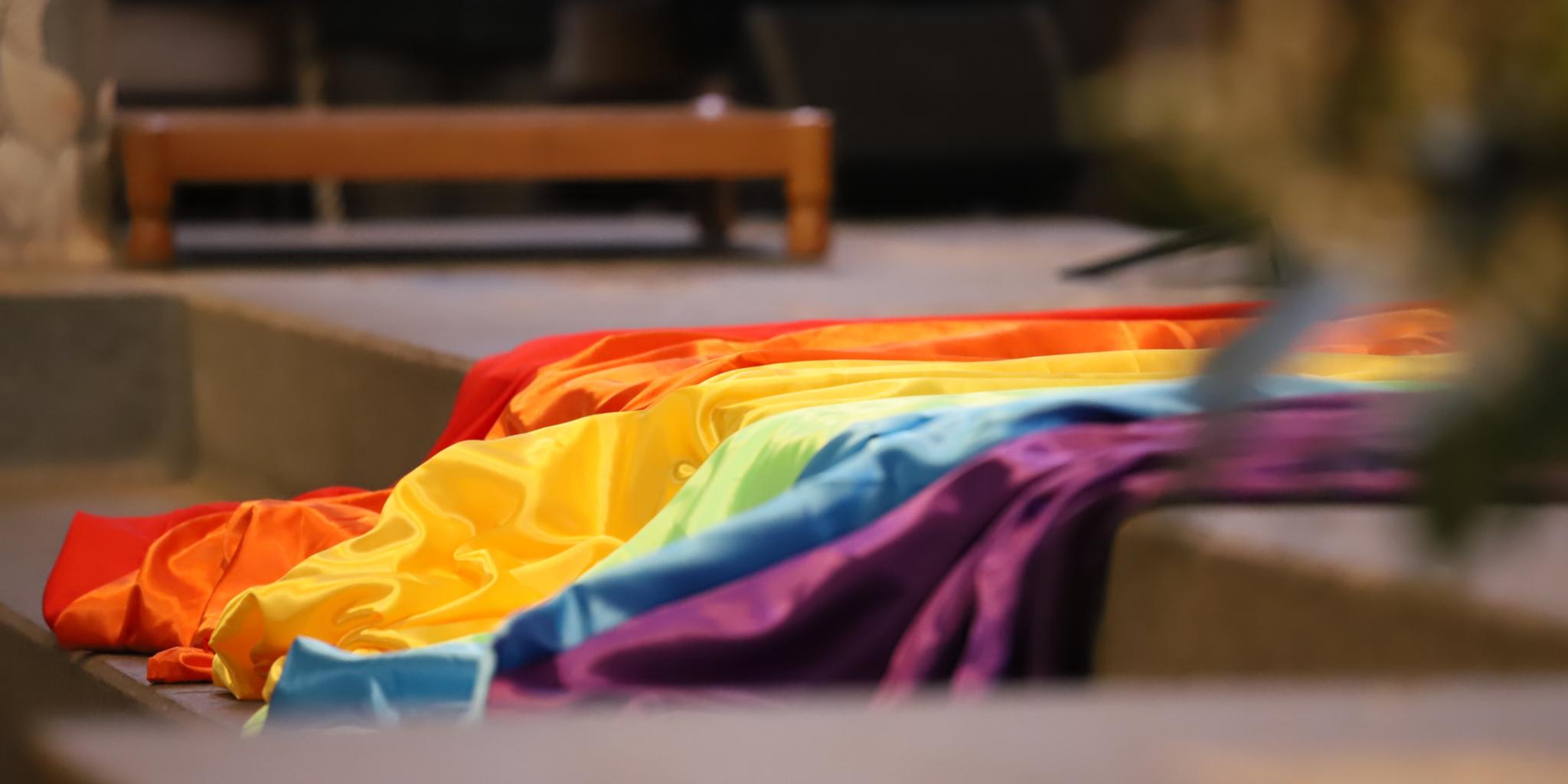 Eine Regenbogenfahne liegt auf einer Treppe