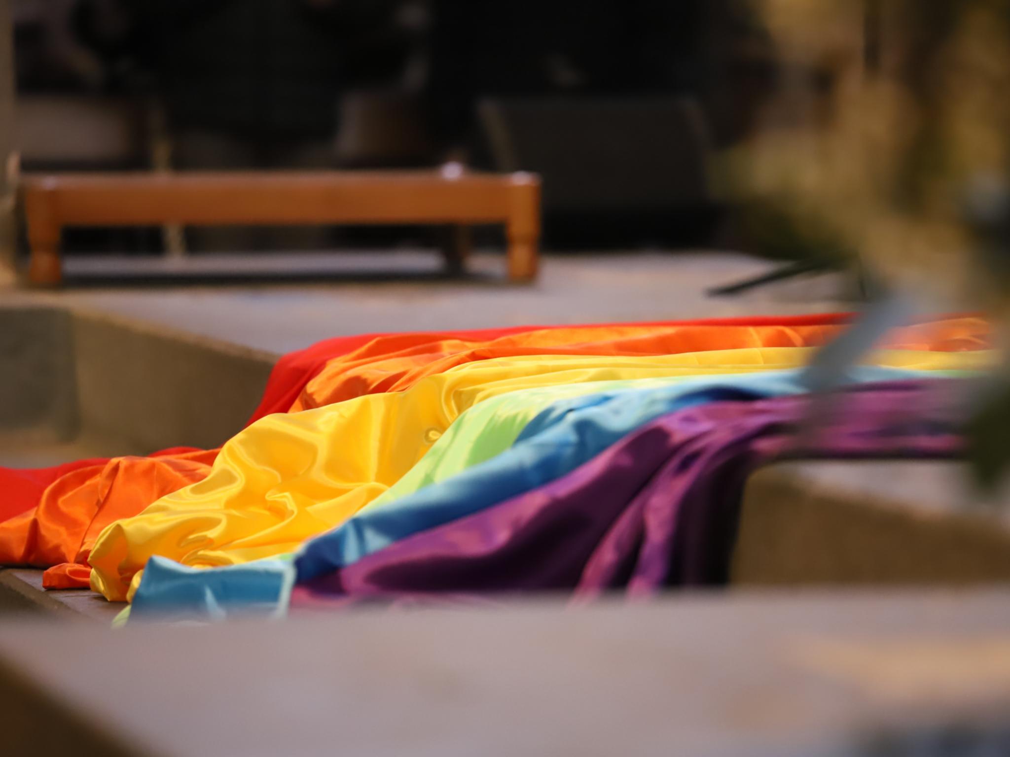 Eine Regenbogenfahne liegt auf einer Treppe