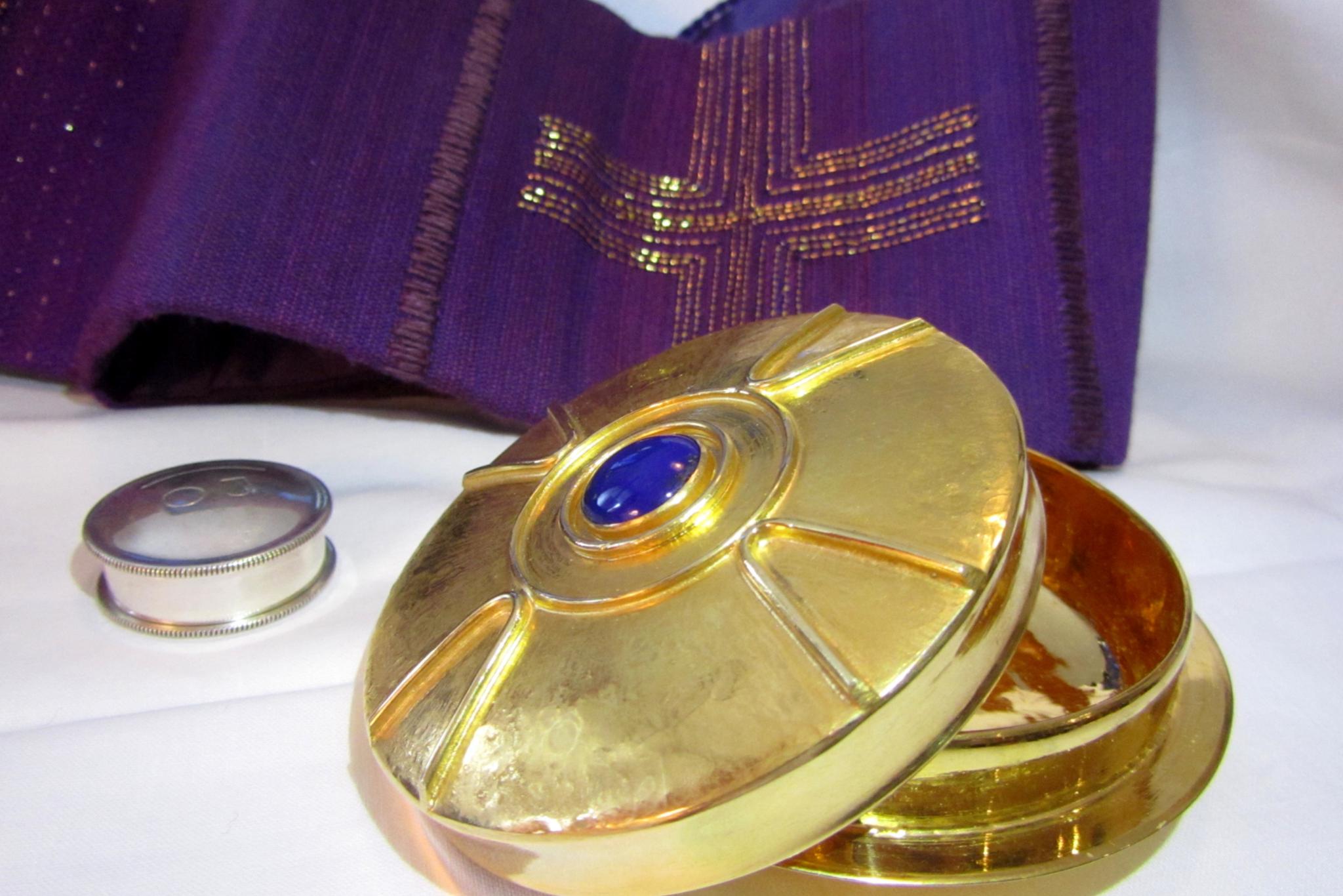 Auf einem Tisch steht eine halb geöffnete kleine Hostienschale. Daneben ein kleiner Behälter mit Salbe. (c) Markus Lidel auf pfarrbriefservice.de Auf einem Tisch steht eine halb geöffnete kleine Hostienschale. Daneben ein kleiner Behälter mit Salbe.