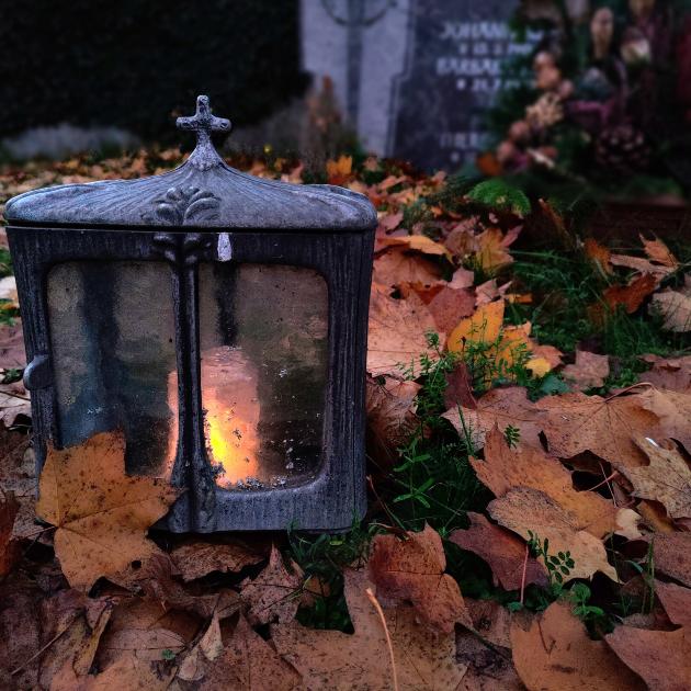 Kerze auf einem Grab bei Nacht