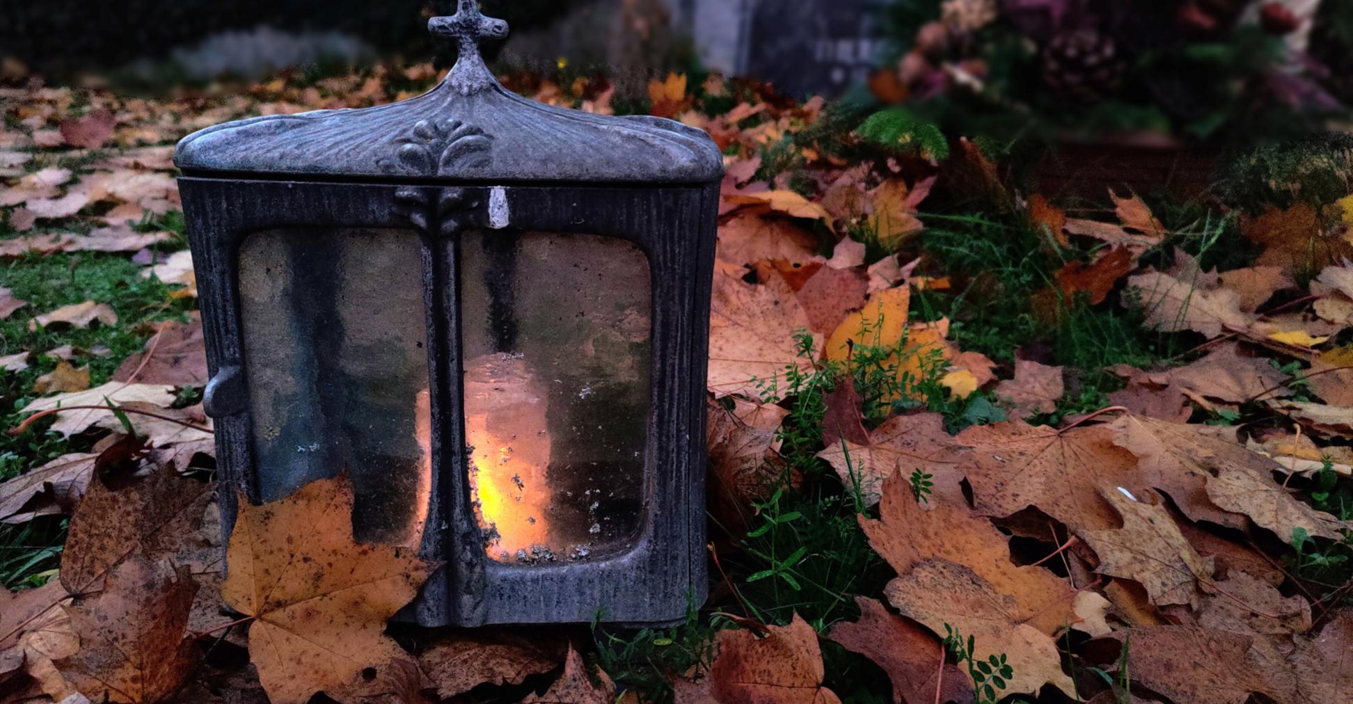 Kerze auf einem Grab bei Nacht