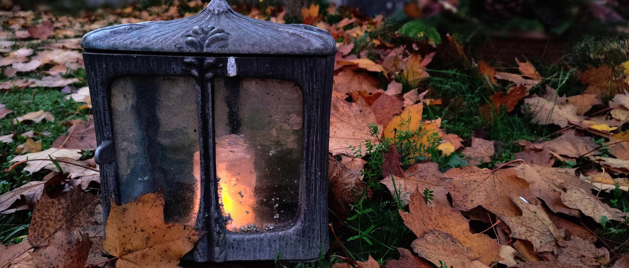 Kerze auf einem Grab bei Nacht