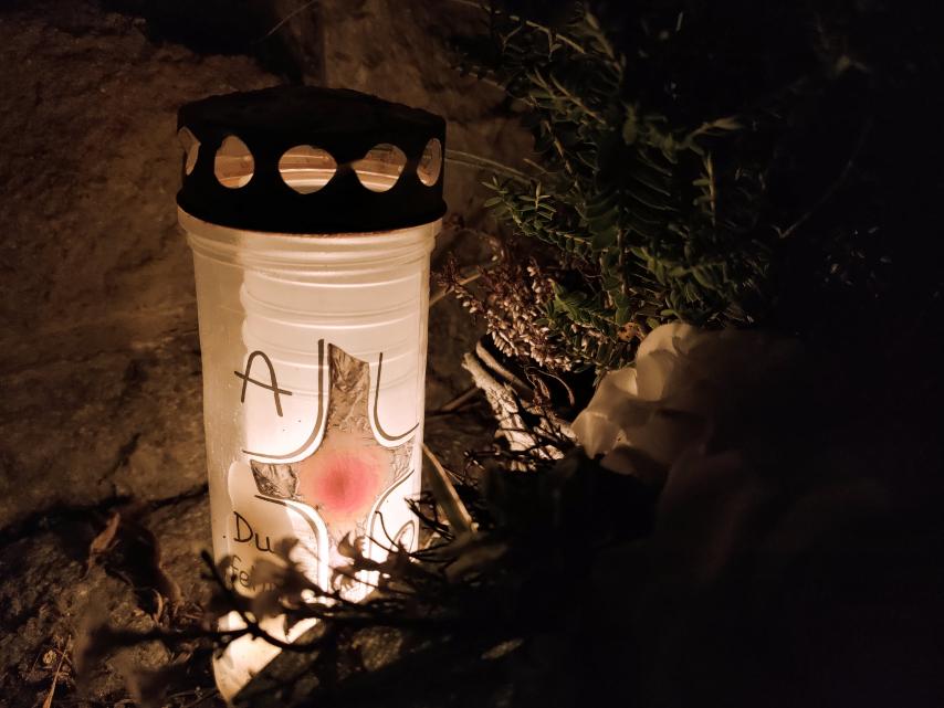 Kerze auf einem Grab bei Nacht