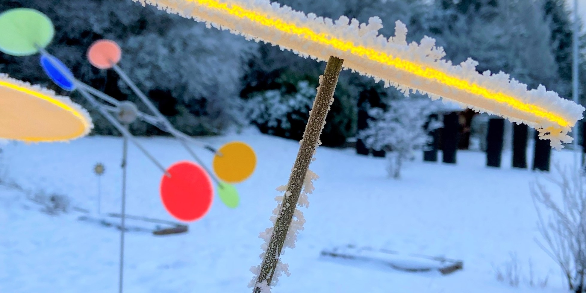 Man sieht mehrere bunte Sonnenfänger in einer schneebedeckten Landschaft