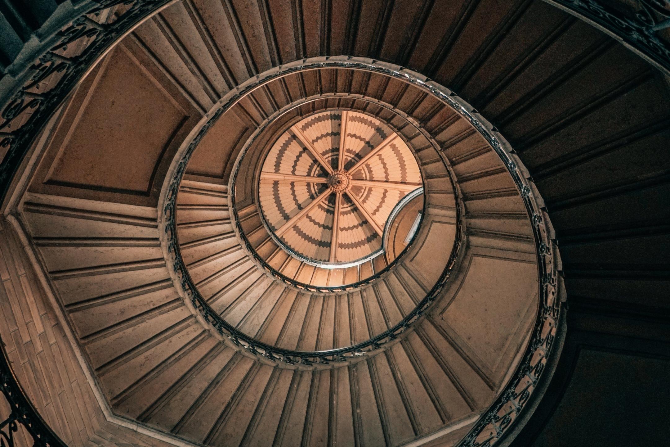 Blick von unten nach oben in ein rundes Treppenhaus.