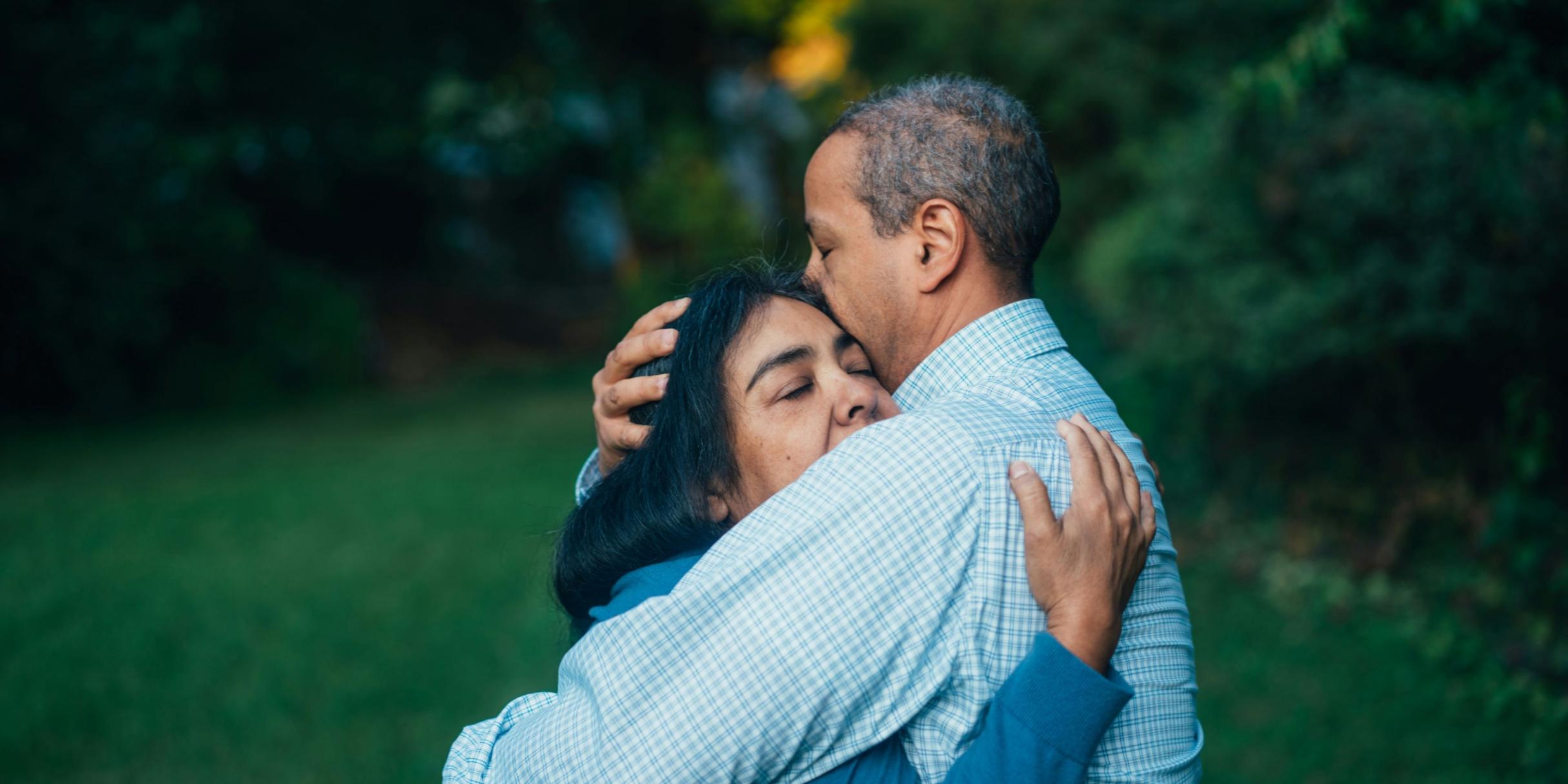 Ein Mann umarmt eine Frau und spendet Trost