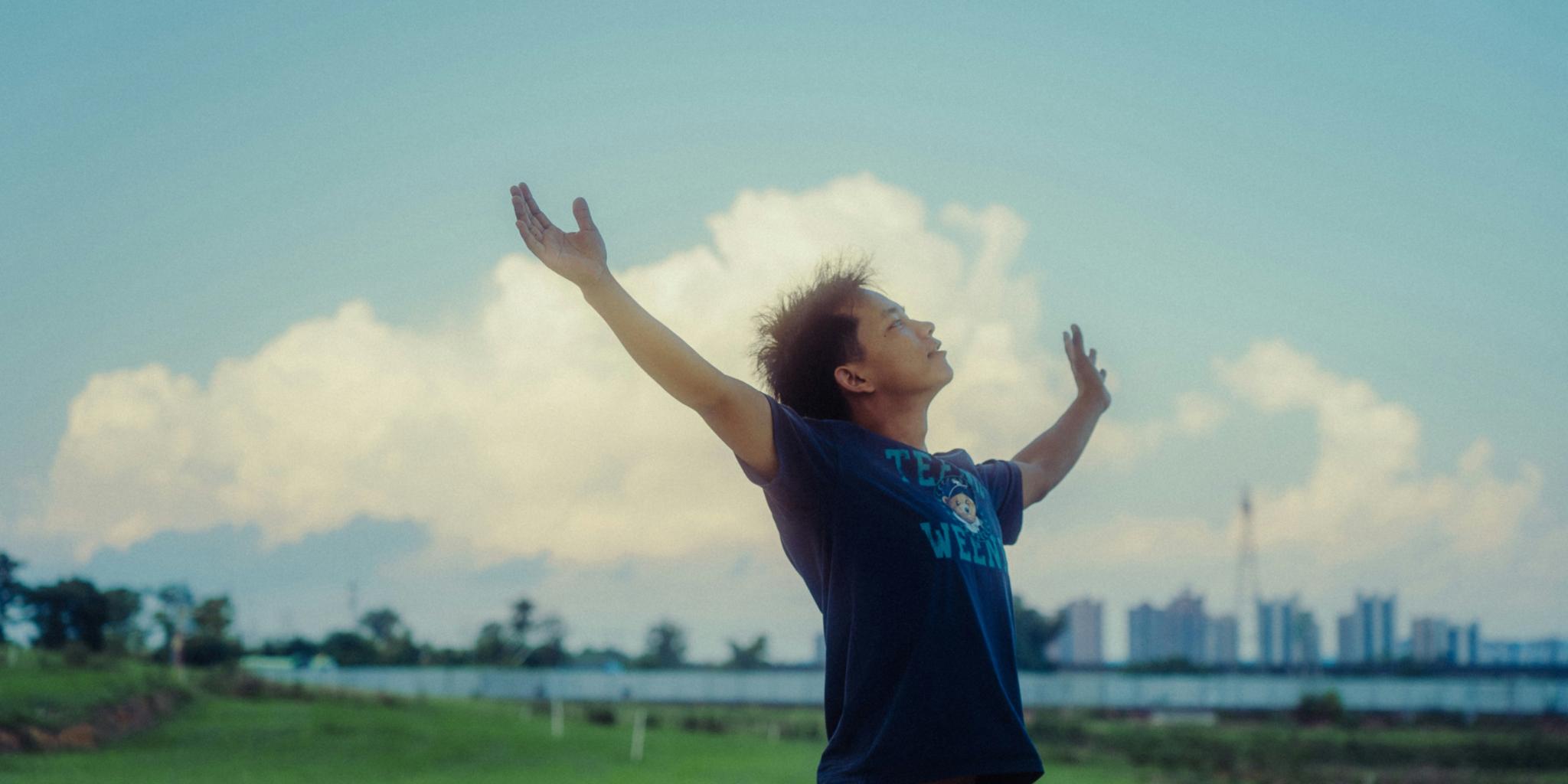 Ein Mann streckt beide Arme weit geöffnet in die Luft (c) Chosen0 / unsplash.com Ein Mann streckt beide Arme weit geöffnet in die Luft