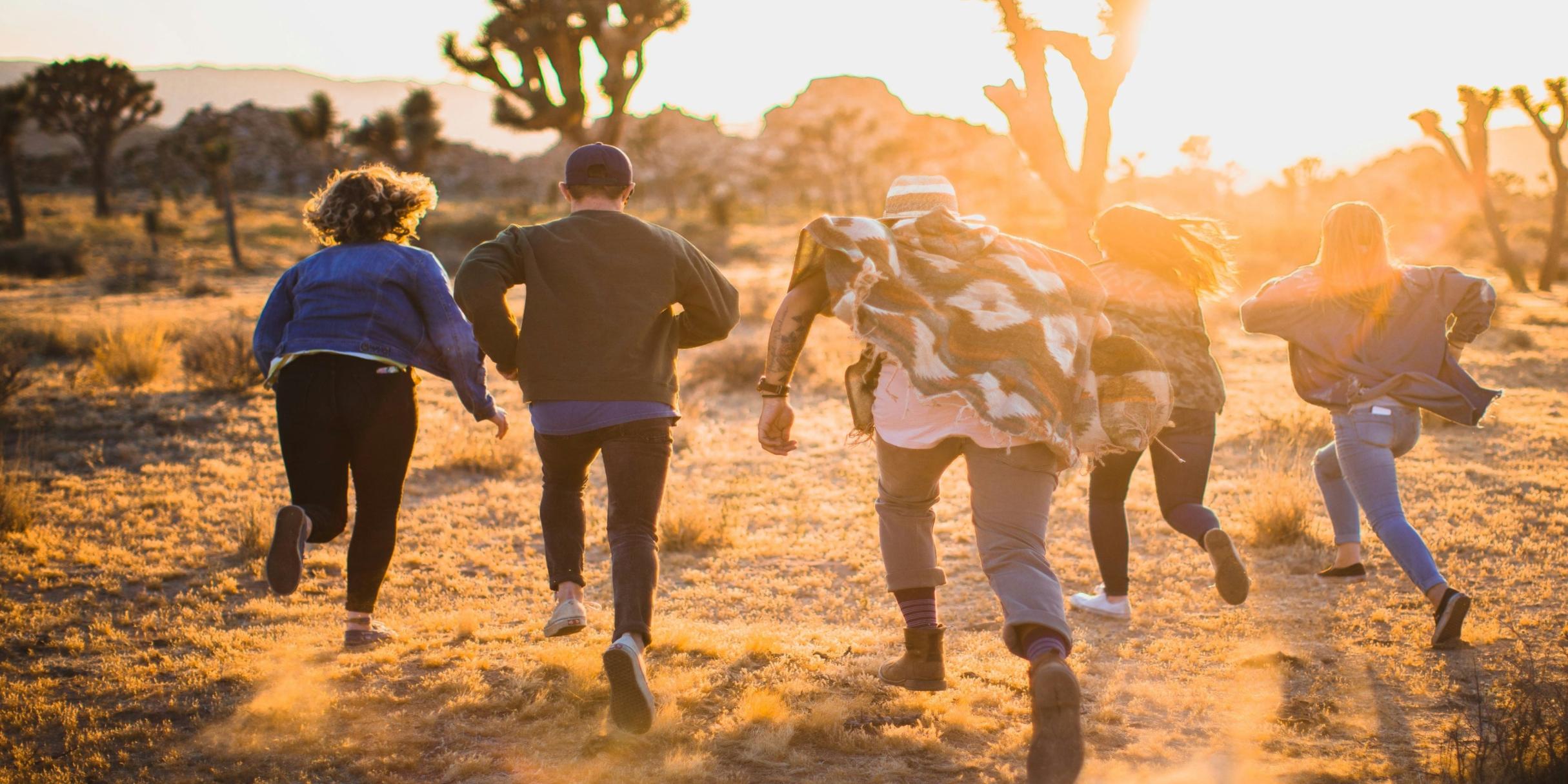 Eine Gruppe von fünf Menschen läuft in den Sonnenuntergang