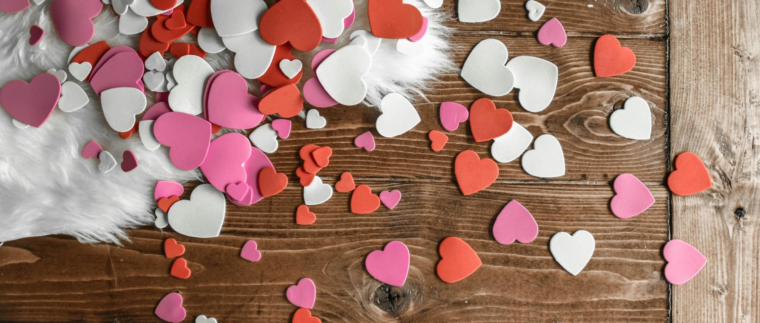 Konfettiherzen liegen auf einem Holztisch