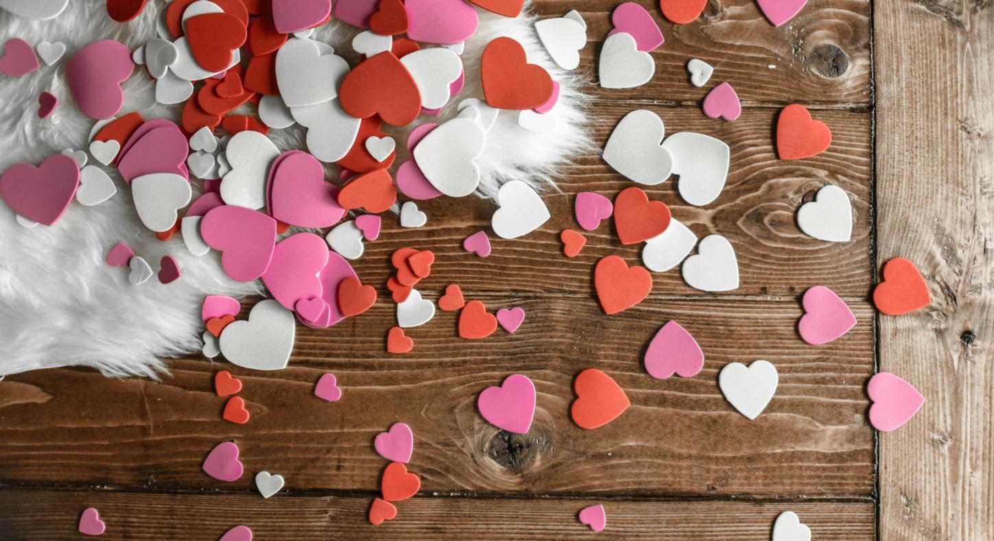 Konfettiherzen liegen auf einem Holztisch