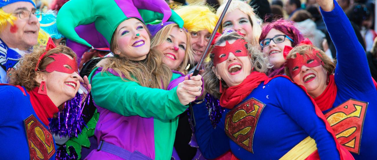 Man sieht eine Gruppe kostümierter Frauen die gemeinsam in ein Handy schauen, um ein Selfie zu machen