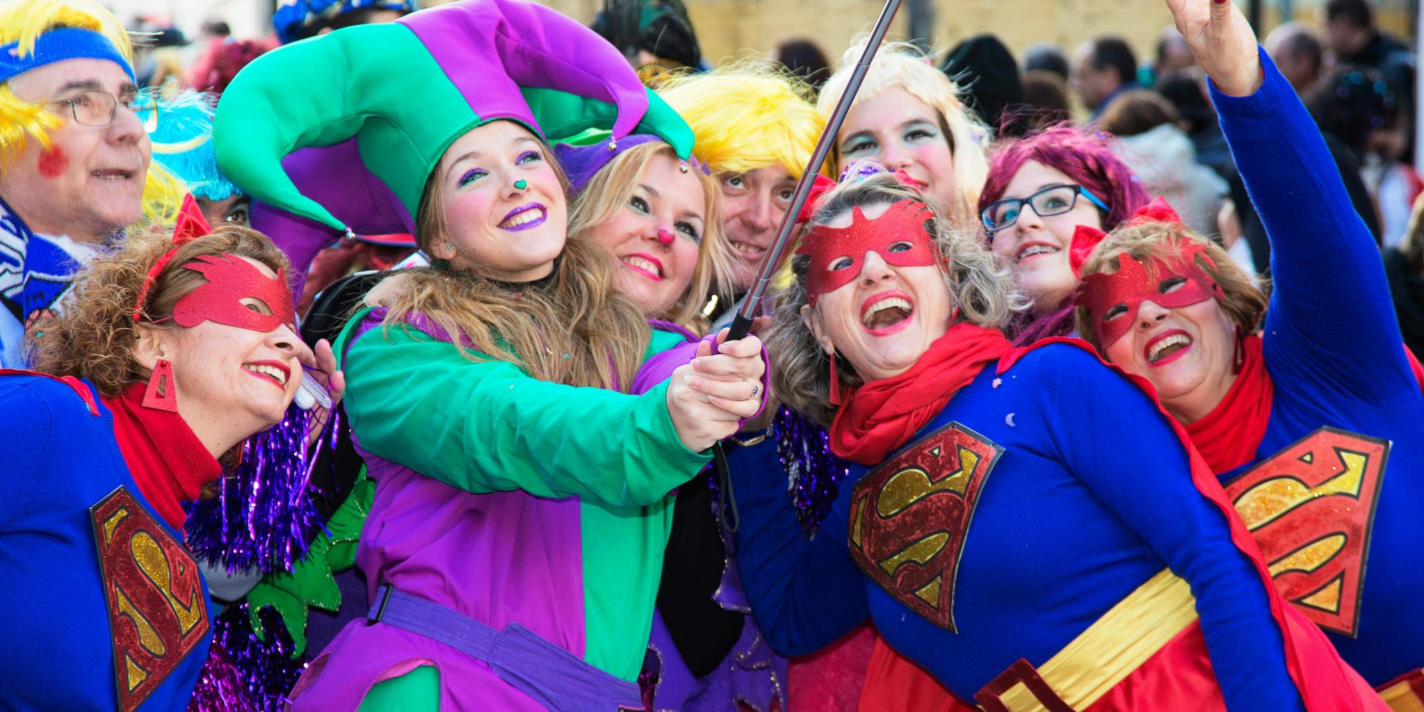 Man sieht eine Gruppe kostümierter Frauen die gemeinsam in ein Handy schauen, um ein Selfie zu machen