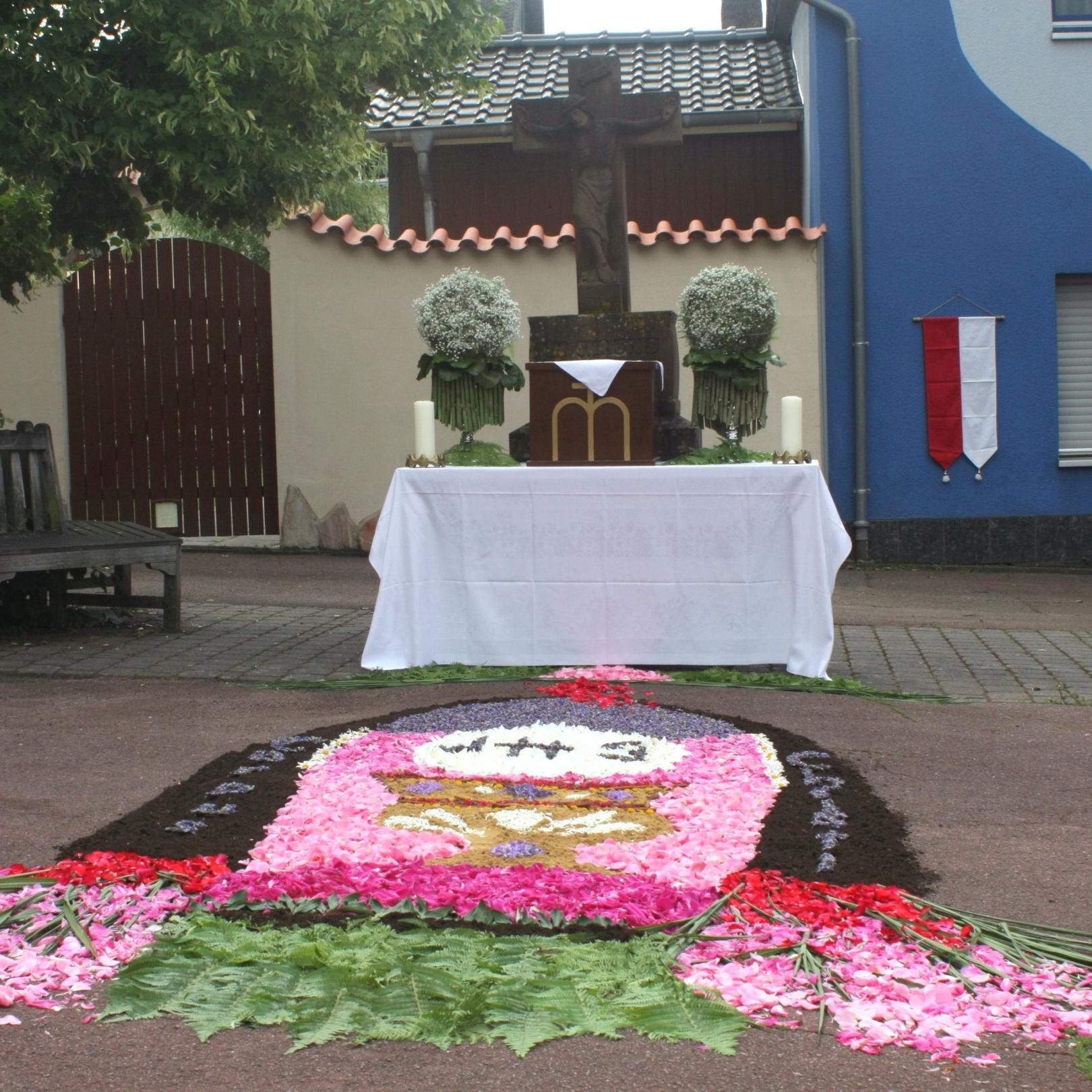 Ein Teppich aus Blüten wurde vor einem Altar gelegt