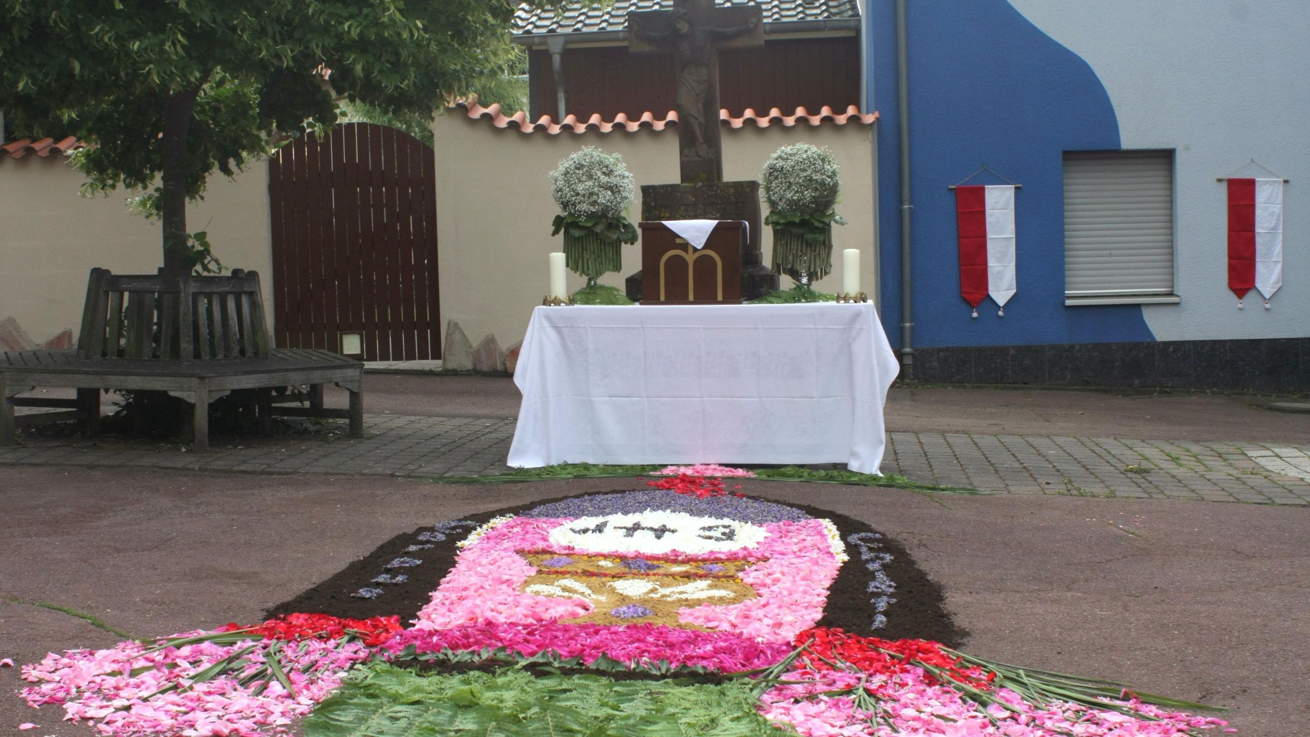 Ein Teppich aus Blüten wurde vor einem Altar gelegt