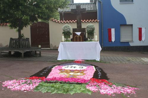 Ein Teppich aus Blüten wurde vor einem Altar gelegt