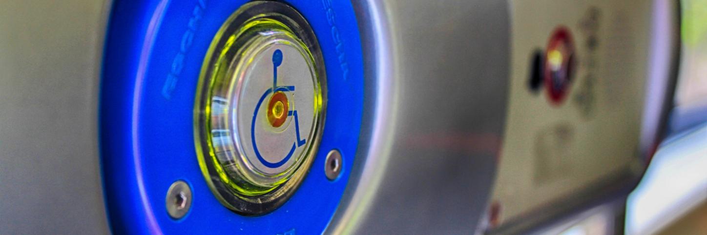 Man sieht einen Kopf zum Drücken, auf dem ein Rollstuhlsymbol abgebildet ist