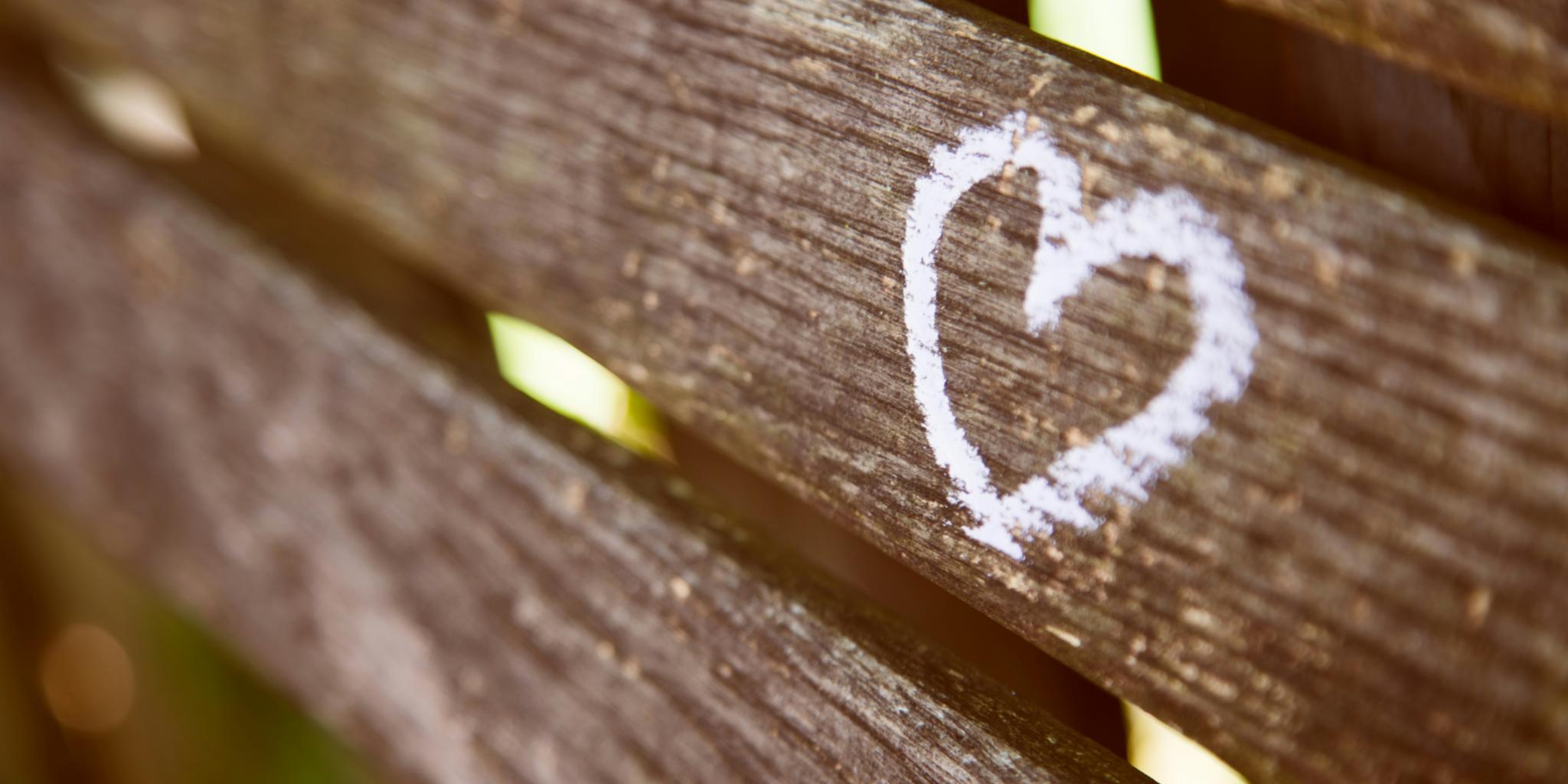 Auf einer Holzlatte ist mit Kreide ein Herz aufgemalt