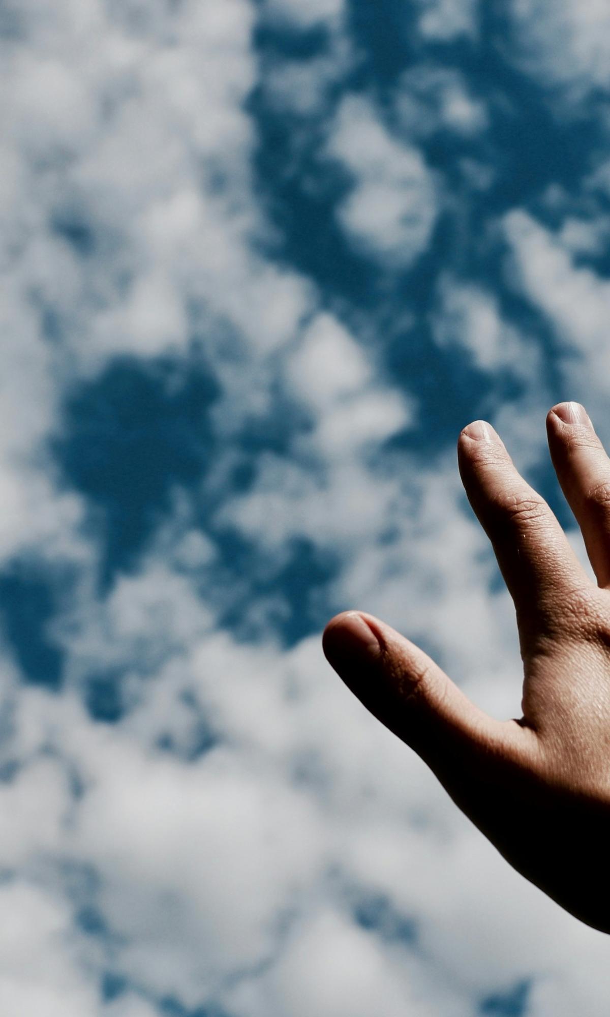 Eine Hand wird Richtung Himmel ausgestreckt