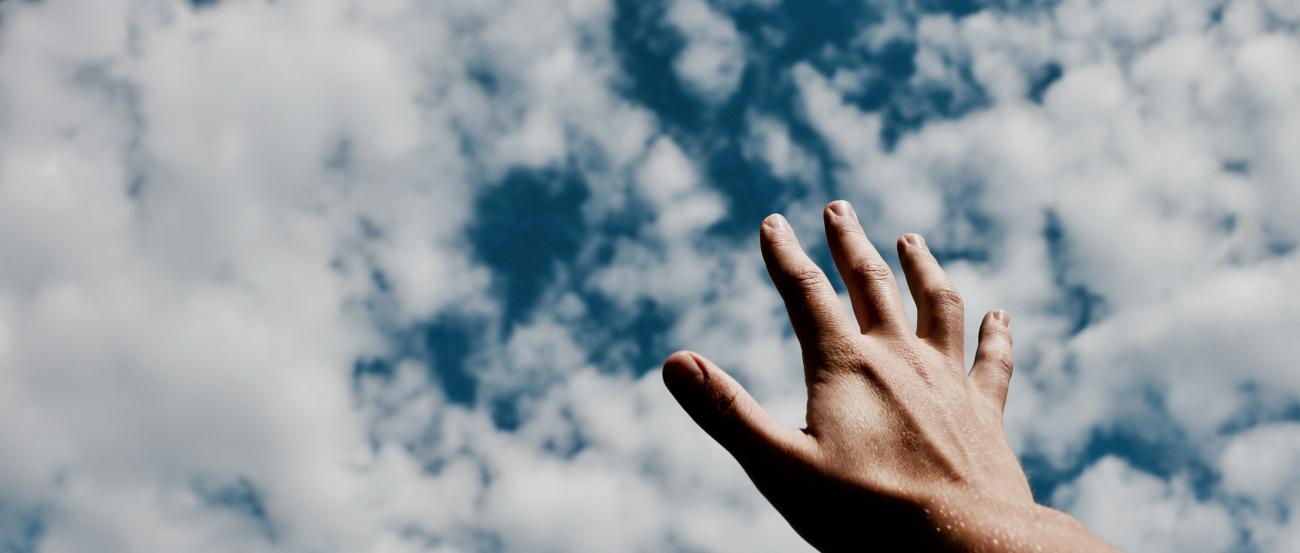 Eine Hand wird Richtung Himmel ausgestreckt