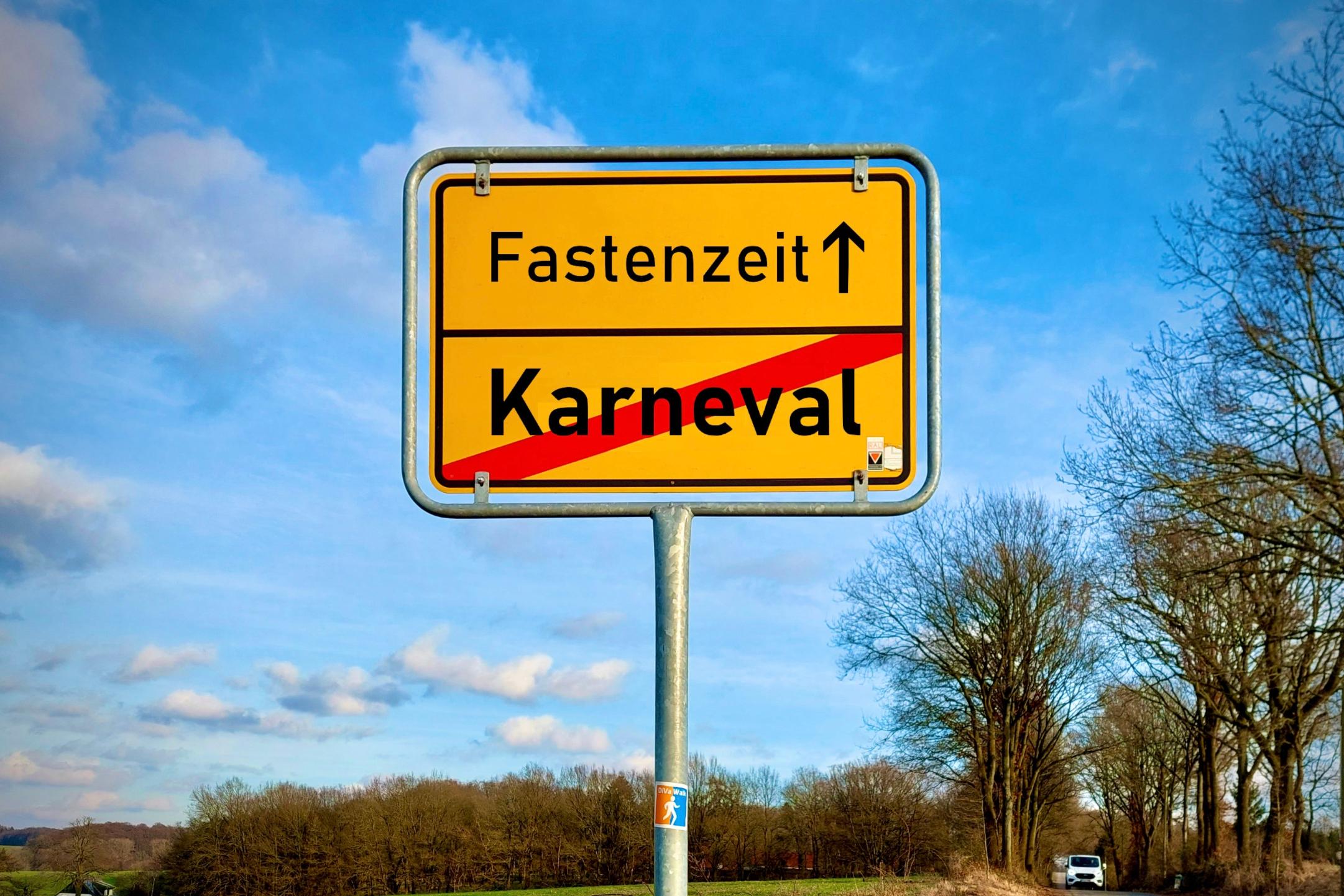 Ein Ortschild in Geld auf dem das Wort Karneval durchgestrichen ist. Darüber steht Fastenzeit mit einem Pfeil der nach vorne weist