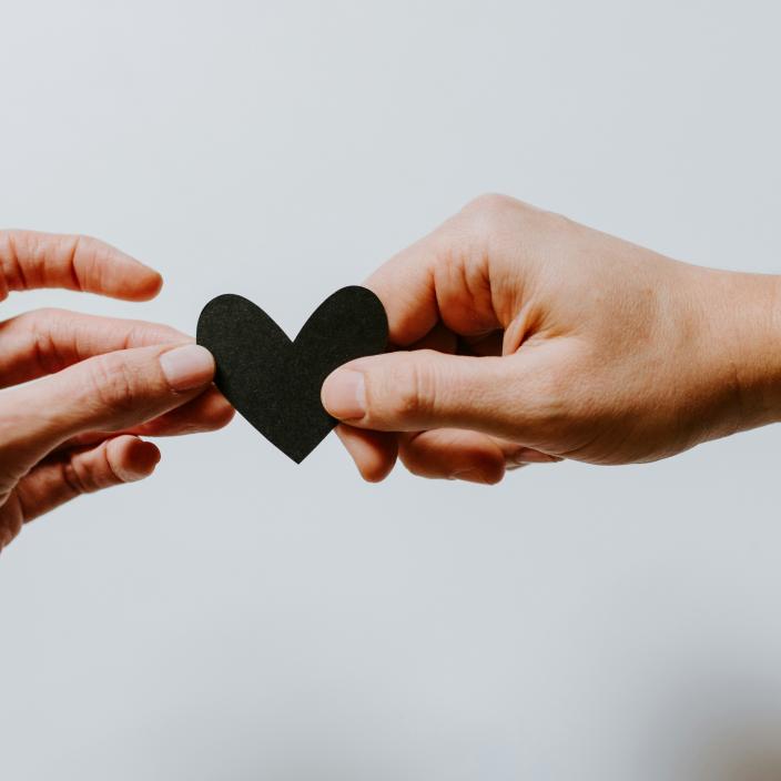 Symbolbild (c) Kelly Sikkema / unsplash.com Zwei Hände halten ein schwarzes Herz gemeinsam fest