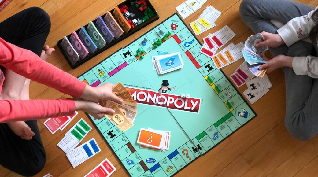 Blick von oben: zwei Kinder spielen Monopoly