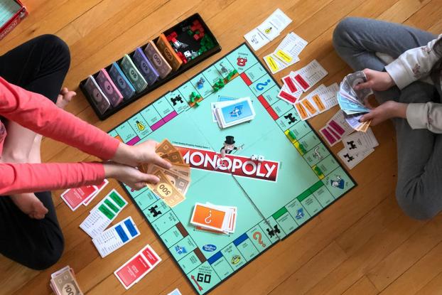 Blick von oben: zwei Kinder spielen Monopoly