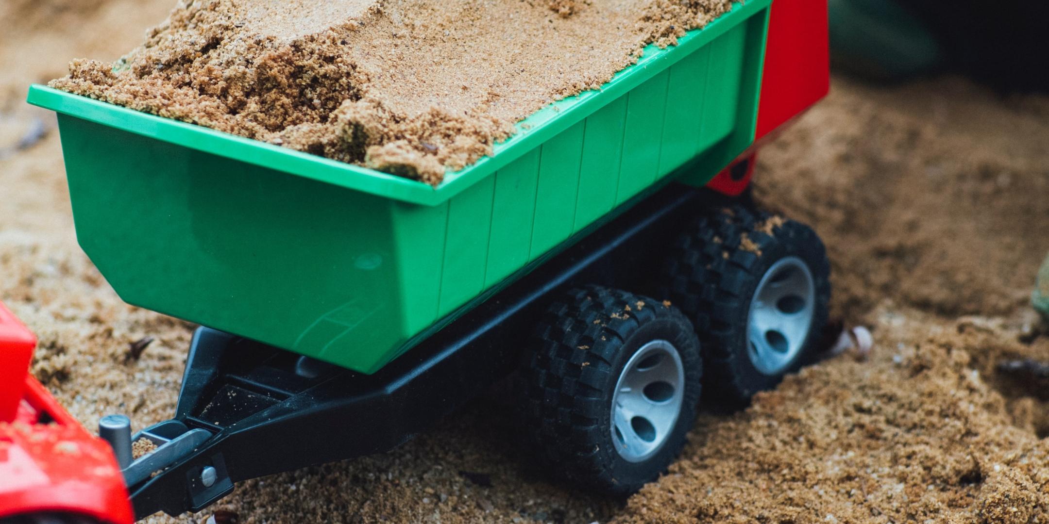 Ein Kind belädt im Sandkasten einen Spielzeuganhänger mit Sand (c) Markus Spiske/unsplash.com Ein Kind belädt im Sandkasten einen Spielzeuganhänger mit Sand